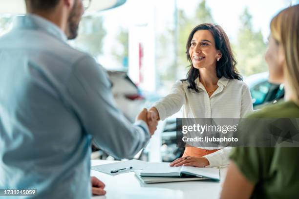sale woman or businesswoman shaking hands with male after car loan agreement was signed. - vertrouwen stockfoto's en -beelden
