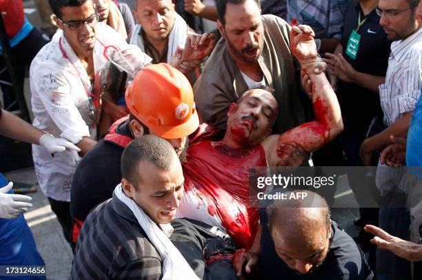 Supporter of the Muslim Brotherhood who was injured during a rally in support of deposed president Mohamed Morsi is carried to a medical facility...