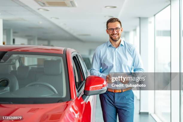 cheerful sales manager with tablet computer standing near new automobile at luxury car salon, copy space - lease agreement stock pictures, royalty-free photos & images