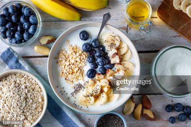 heidelbeeren, bananenscheiben, haferflocken und joghurt - rolled oats stock-fotos und bilder