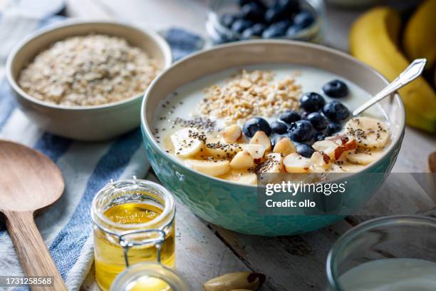 heidelbeeren, bananenscheiben, haferflocken und joghurt - rolled oats stock-fotos und bilder