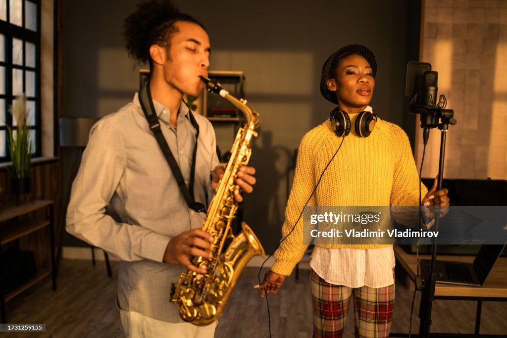 A singer and a saxophone player recording their music