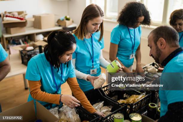 operatori di beneficenza che confezionano donazioni di cibo - aiuti umanitari foto e immagini stock