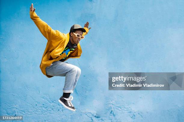 urbaner afrikanischer mann, der hoch springt - hip hop stock-fotos und bilder