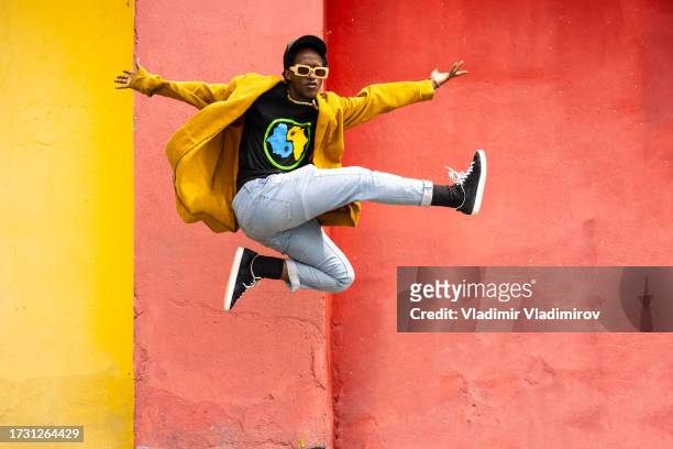 excited young african man is jumping - afroamerikansk kultur bildbanksfoton och bilder