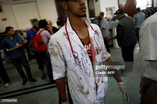 Medic in a stained white robe is seen at a make shift hospital where victims are being brought following clashes between Egyptian police and Muslim...