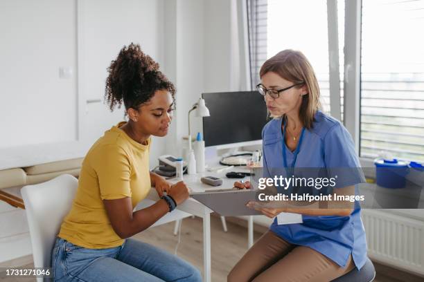 gynaecologist talking with young girl at annual gynaecology check up. - análisis ginecológico fotografías e imágenes de stock