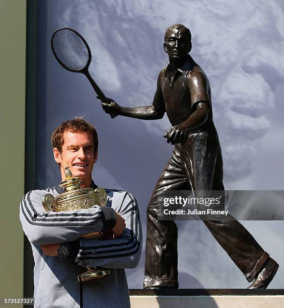 Andy Murray of Great Britain poses with the Gentlemen's Singles Trophy next to the Fred Perry statue at Wimbledon on July 8, 2013 in London, England.