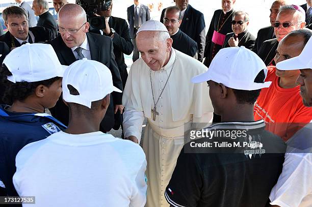 Pope Francis meets a group of immigrants at the pier of the island on July 8, 2013 in Lampedusa, Italy. On his first official trip outside Rome, Pope...