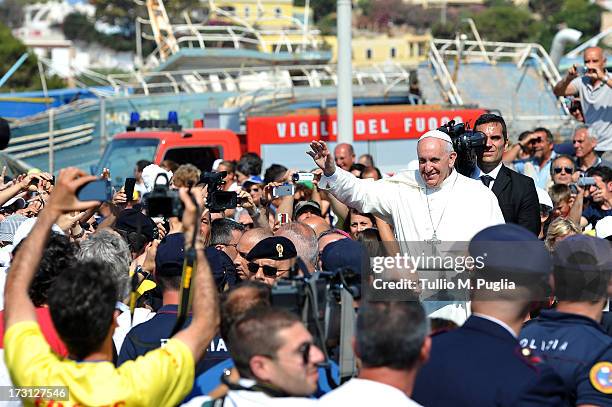 Pope Francis waves to the faithful as he arrives in the island on July 8, 2013 in Lampedusa, Italy. On his first official trip outside Rome, Pope...