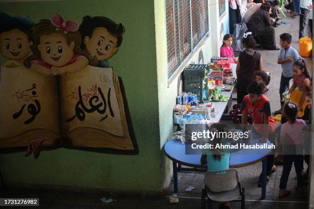 Displaced Palestinian citizens gather at the UNRWA Beach School, after evacuating their homes damaged by Israeli air strikes, on October 12, 2023 in...