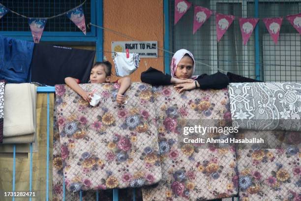 Displaced Palestinian citizens gather at the UNRWA Beach School, after evacuating their homes damaged by Israeli air strikes, on October 12, 2023 in...