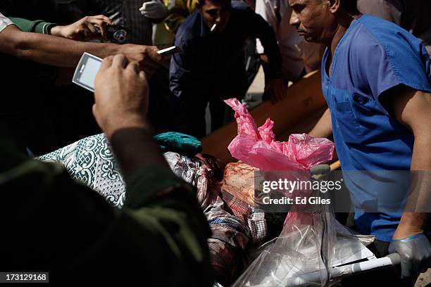 The body of a man is carried on a stretcher at the Liltaqmeen al-Sahy Hospital in Cairo's Nasr City district, after allegedly being killed during a...