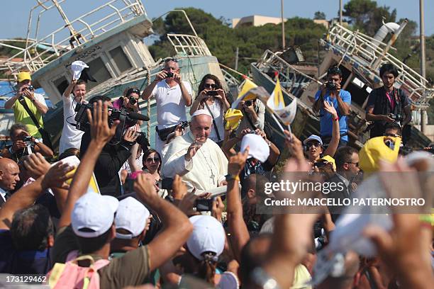 Pope Francis passes by remains of migrants boats as he waves upon arrival during his visit to the island of Lampedusa, a key destination of tens of...