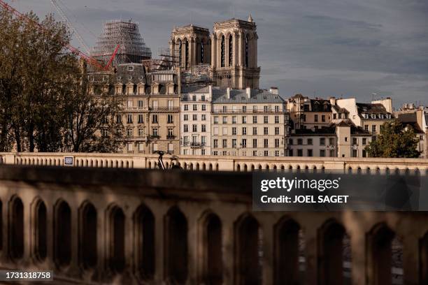 This photograph taken in central Paris, on October 18 shows a crane in front of Notre-Dame de Paris Cathedral, as reconstruction work is ongoing. The...