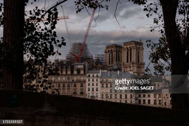 This photograph taken in central Paris, on October 18 shows a crane in front of Notre-Dame de Paris Cathedral, as reconstruction work is ongoing. The...