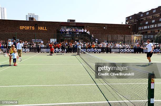 Andy Murray of Great Britain plays a shot to a young tennis fan during an event for the new Wimbledon Champion to meet fans following his victory in...