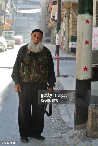 Syrian rebel fighter Abu Al Dardaa walks towards the front-line as rebels attack regular Syrian army areas in the Salaheddine neighborhood of Aleppo,...