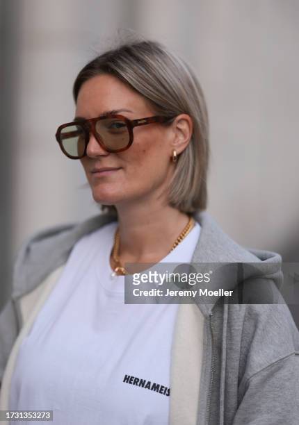 Victoria Thomas is seen wearing aviator sunglasses with havana frame from Hernameis the label, golden chunky small hoop earrings from Christ, a...