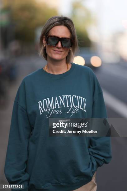 Victoria Thomas is seen wearing large sunglasses with havana frame and blue lenses from Loewe, golden chunky small hoop earrings from Christ, a...