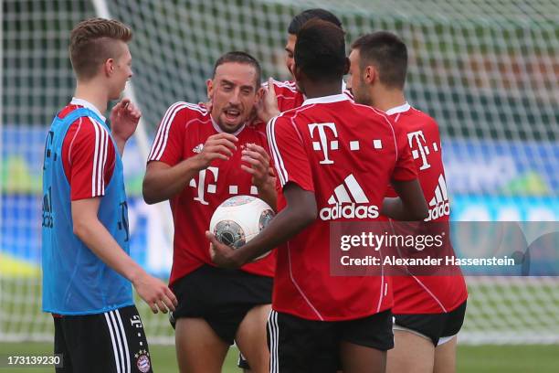 Franck Ribery of FC Bayern Muenchen jokes with his team mates Mitchel Weiser , Emre Can , David Alaba and Diego Contento after a training session at...