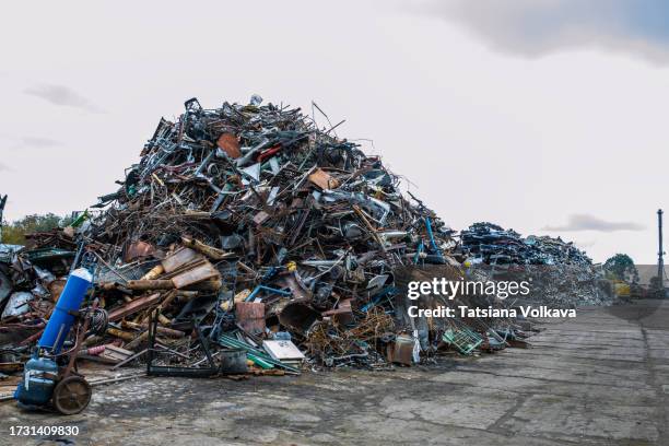 piles of metal scrap tower amidst vast sea of discarded metal under open sky - scrap yard stock pictures, royalty-free photos & images