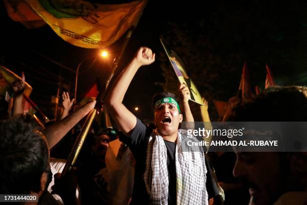Iraqis shout slogans during a demonstration near the suspension bridge leading to Baghdad's Green Zone and the US Embassy in Baghdad on October 18...