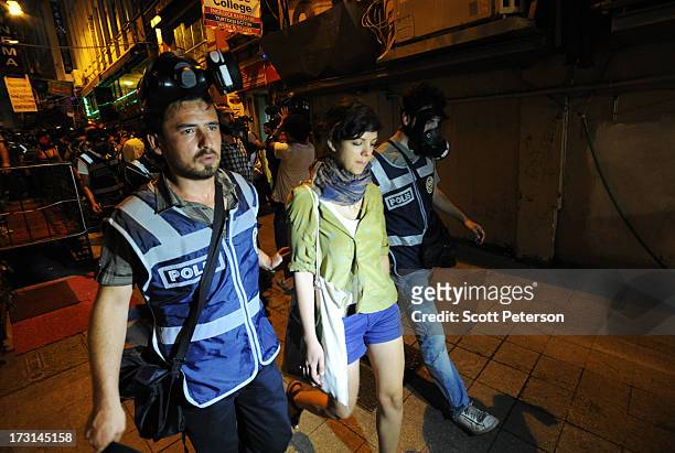 Turkish police arrest a woman as they pursue anti-government protestors along the Istiklal shopping street near Taksim Square on July 8, 2013 in...
