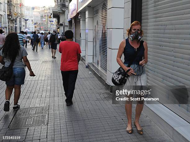 Woman wears a gas mask as Turkish police battle anti-government protestors along the Istiklal shopping street near Taksim Square on July 8, 2013 in...