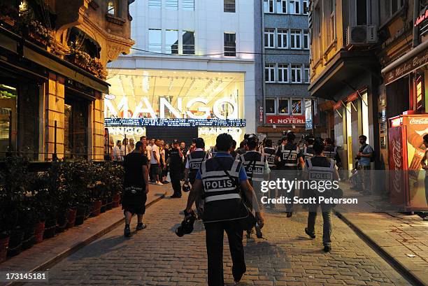 Turkish police pursue anti-government protestors along the Istiklal shopping street near Taksim Square on July 8, 2013 in Istanbul, Turkey. The...