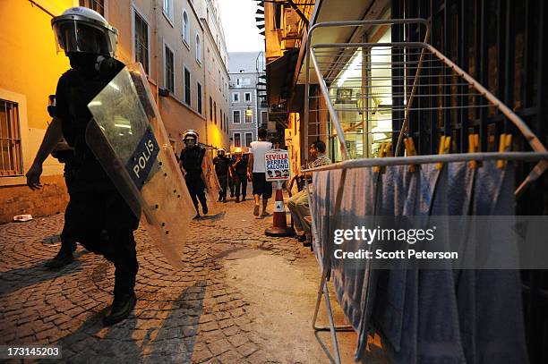 Turkish police pass a barber shop, as they battle anti-government protestors along the Istiklal shopping street near Taksim Square on July 8, 2013 in...