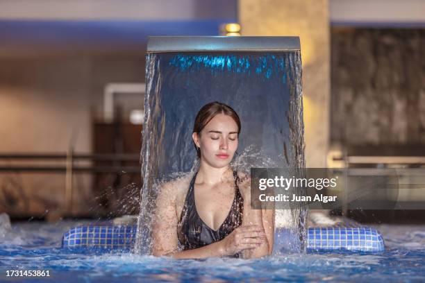 woman with her eyes closed relaxing in a spa swimming pool - algar waterfall spain stock pictures, royalty-free photos & images