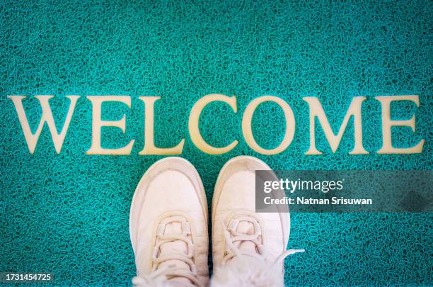 mat with shoes near entrance door, welcome home concept. - zerbino foto e immagini stock