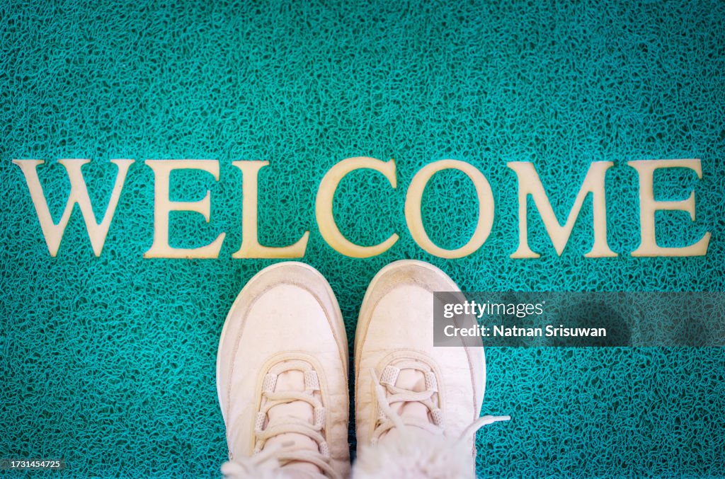 Mat with shoes near entrance door, welcome home concept.