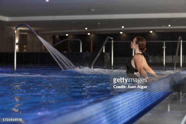 a young woman in a swimsuit relaxes in the pool of a spa - algar waterfall spain stock pictures, royalty-free photos & images