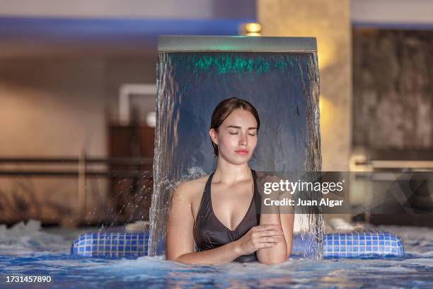 young woman in a spa pool under the whirlpool jet - algar waterfall spain stock pictures, royalty-free photos & images