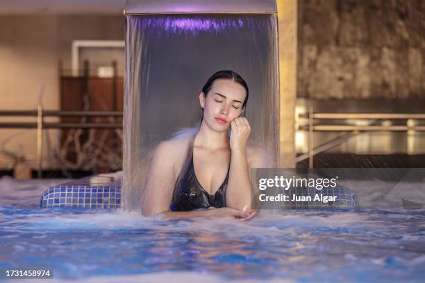 beautiful woman with her eyes closed inside the spa pool - algar waterfall spain stock pictures, royalty-free photos & images