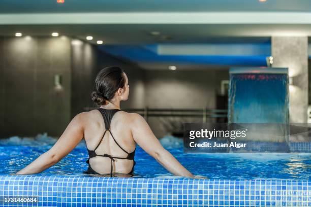young woman enjoying a bath in whirlpool pool - algar waterfall spain stock pictures, royalty-free photos & images