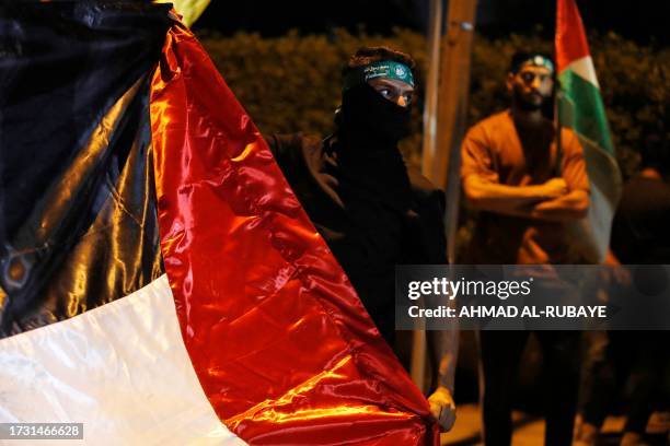 Iraqis take part in a demonstration near the suspension bridge leading to Baghdad's Green Zone and the US Embassy in Baghdad on October 18 protesting...