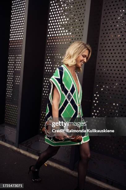 Helena Bordon wears a v-neck green and blue Gucci long cardigan worn as a mini short dress, a brown leather bag, and black tights outside Gucci...