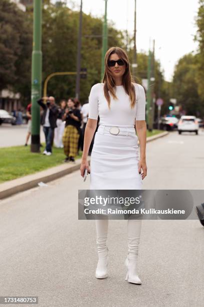 Camille Charriere wears a white high-waisted skirt, shirt, and boots outside Ferragamo during the Milan Fashion Week - Womenswear Spring/Summer 2024...