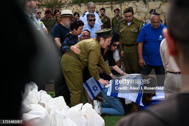 Family and soldiers support the mother and sister of Valentin Ghnassia who was killed in a battle with Hamas militants at Kibbutz Be’eeri near the...