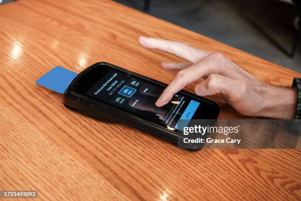 man pays bill at restaurant with credit card on wireless device - kreditkartenlesegerät stock-fotos und bilder