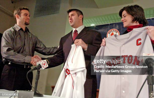 Red Sox general manager Theo Epstein, left, shakes hands with catcher Jason Varitek, after surprising him with team captain jerseys at a press...