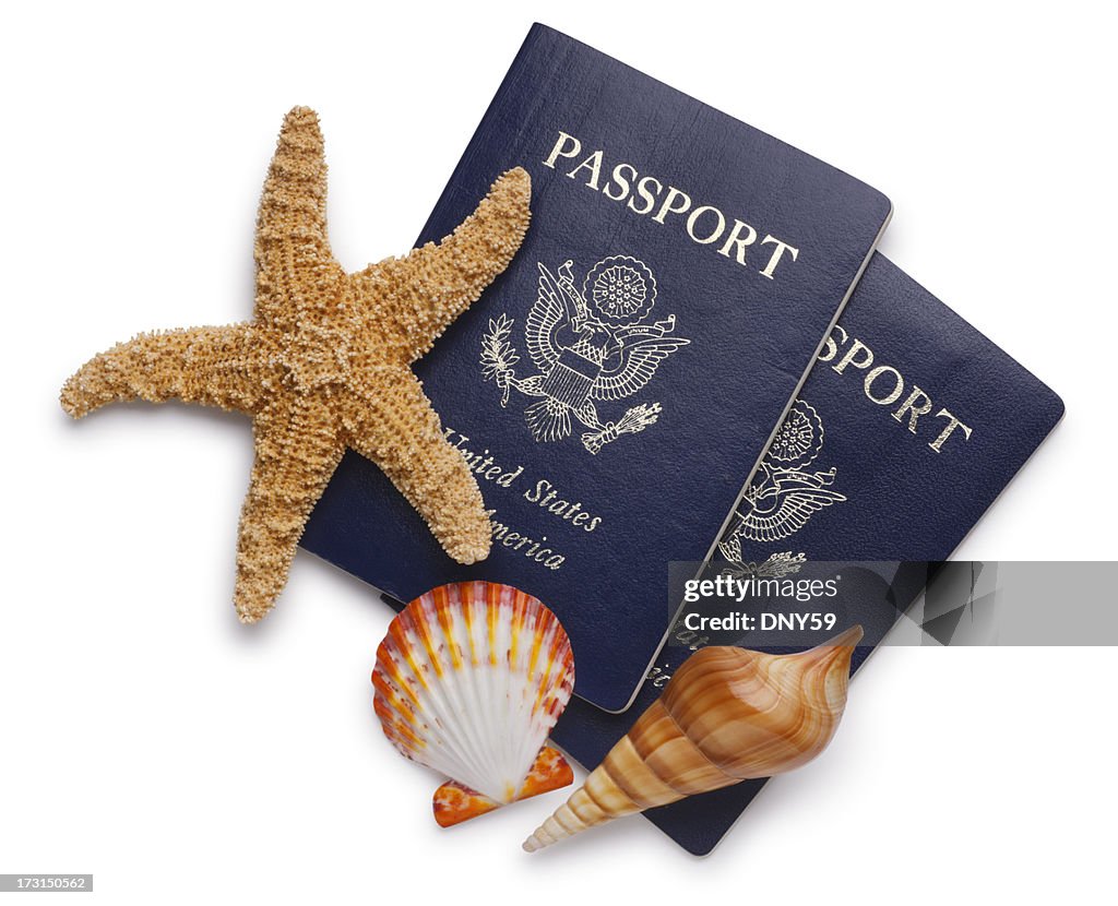 Two U.S. passports and sea shells isolated on white background.