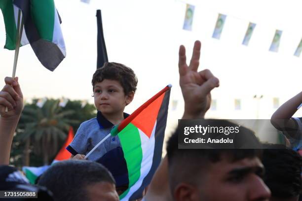 People, holding banners and Palestinian flags, gather in front of the Abu Hanifa an-Numan Mosque to protest against the bombing of Gaza's Al-Ahli...