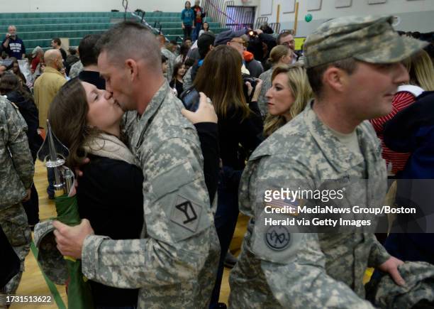 Michele Levicki, left, of Grafton, kisses Spc. Travis Lash as Lash along with approximately 130 Soldiers from the 747th Military Police Company and...