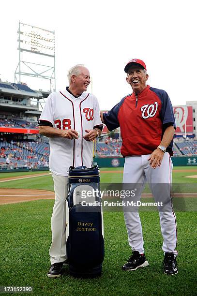 Ted Bishop, President of The PGA of America, talks with Davey Johnson of the Washington Nationals before presenting him with a PGA golf bag before a...
