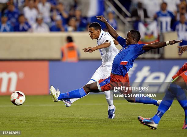 Rony Martinez of Honduras shoots past Mechak Jerome of Haiti to score his first half goal during the 2013 CONCACAF Gold Cup match July 8, 2013 at Red...