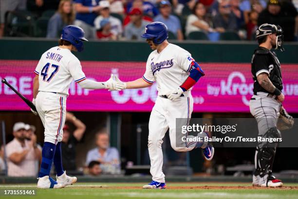 Mitch Garver celebrates with Josh Smith of the Texas Rangers after hitting a home run during a game against the Chicago White Sox at Globe Life Field...